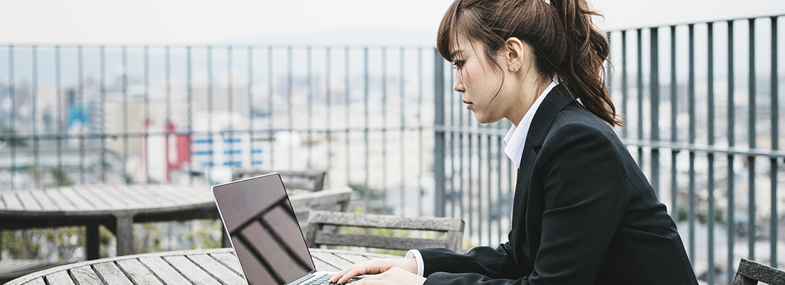 Uma mulher em Quioto, no Japão, trabalha num computador portátil ao ar livre